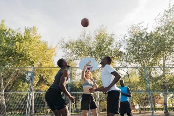 Teenager group having fun playing basketball at the basketball court